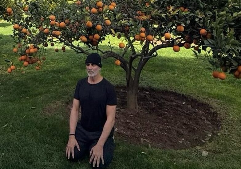 अक्षय कुमार संतरे के पेड़ के नीचे ध्यान करते हुए, 2026 में धैर्य और विकास का संदेश देते हुए