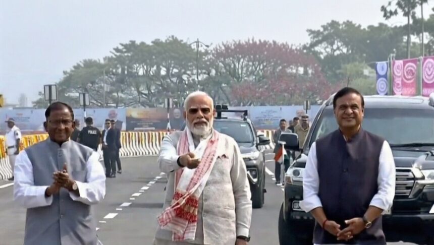 नरेंद्र मोदी असमिया गमोसा पहनकर कुमार भास्कर वर्मा सेतु पर पैदल चलते हुए, असम की सांस्कृतिक विरासत को सम्मान देते हुए।