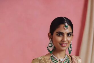 ईशा अंबानी गोल्डन जरदोजी लहंगे में हीरे-पन्ने की जूलरी पहने अपनी बेटी के साथ शादी समारोह में रॉयल अंदाज में नजर आती हुईं।