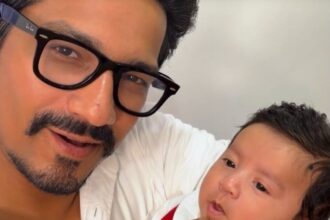 भारती सिंह और हर्ष लिम्बाचिया अपने दूसरे बेटे यशवीर उर्फ काजू को गोद में लिए हुए, फेस रिवील के दौरान मुस्कुराते नजर आ रहे हैं।