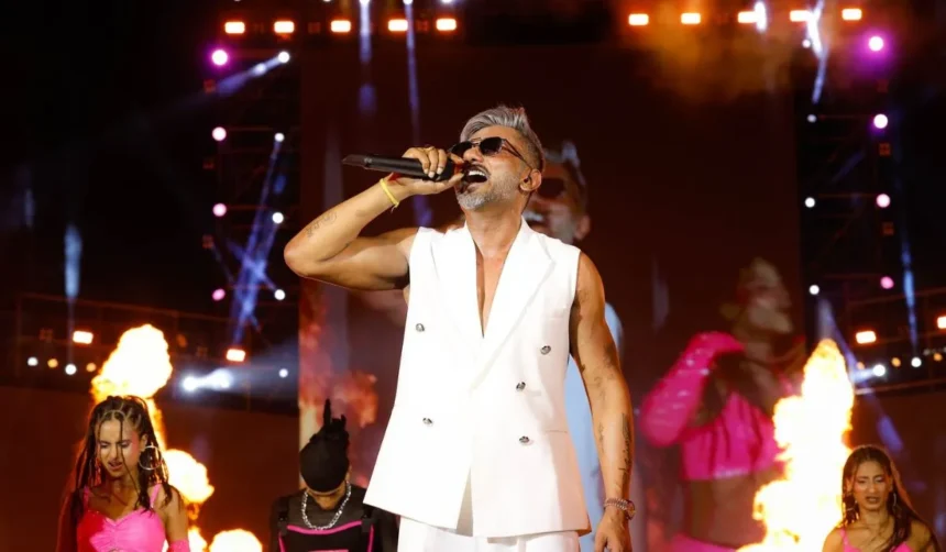 मुंबई कॉन्सर्ट में परफॉर्म करते यो यो हनी सिंह, स्टेज पर तेज लेजर लाइट्स और भीड़ के बीच लाइव शो का दृश्य।
