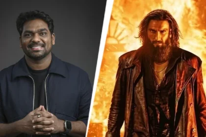 स्क्रीन अवार्ड्स 2026 के मंच पर मुस्कुराते हुए ज़किर खान, हाथ में माइक थामे हुए और बैकग्राउंड में 'धुरंधर 2' का पोस्टर