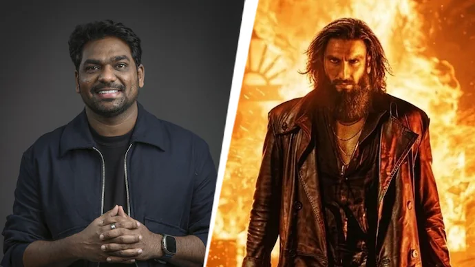 स्क्रीन अवार्ड्स 2026 के मंच पर मुस्कुराते हुए ज़किर खान, हाथ में माइक थामे हुए और बैकग्राउंड में 'धुरंधर 2' का पोस्टर