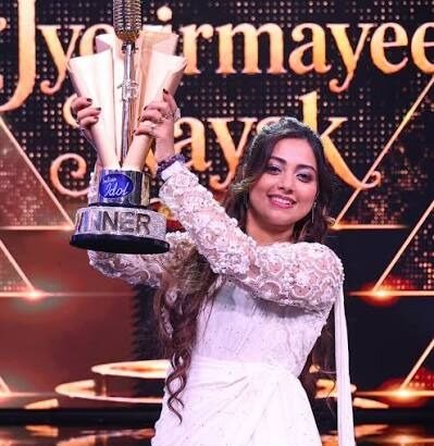 ज्योतिर्मयी नायक Indian Idol 16 की ट्रॉफी जीतने के बाद ट्रॉफी और पुरस्कार राशि के साथ मुस्कुराते हुए।