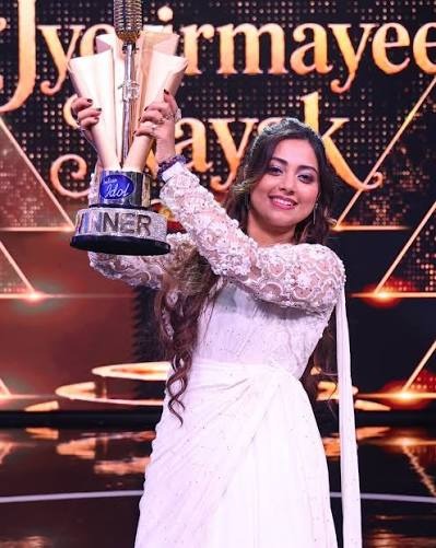 ज्योतिर्मयी नायक Indian Idol 16 की ट्रॉफी जीतने के बाद ट्रॉफी और पुरस्कार राशि के साथ मुस्कुराते हुए।