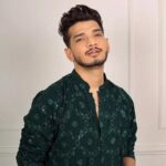 The Traitors Season 2 में होस्ट करण जौहर और कंटेस्टेंट मुनव्वर फारुकी की झलक।