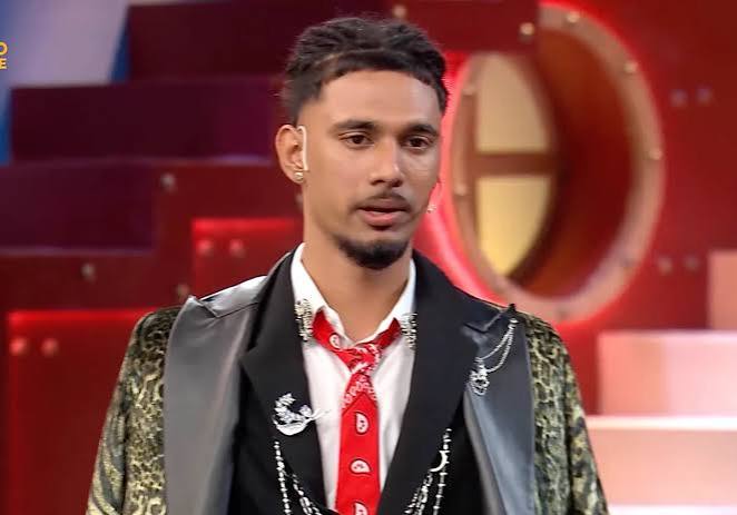 Bigg Boss 20 Reality show contestant in a black stylish jacket and red tie