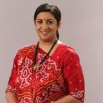 Smiling Indian woman wearing a red traditional saree