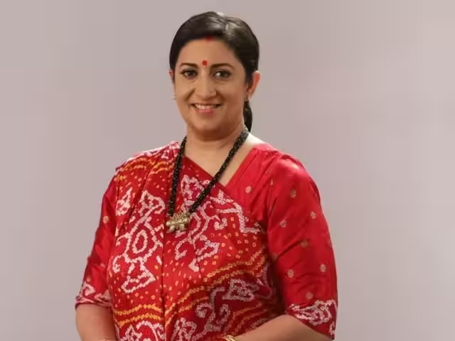 Smiling Indian woman wearing a red traditional saree