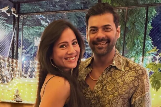 A smiling couple posing together at an event in traditional and festive outfits.